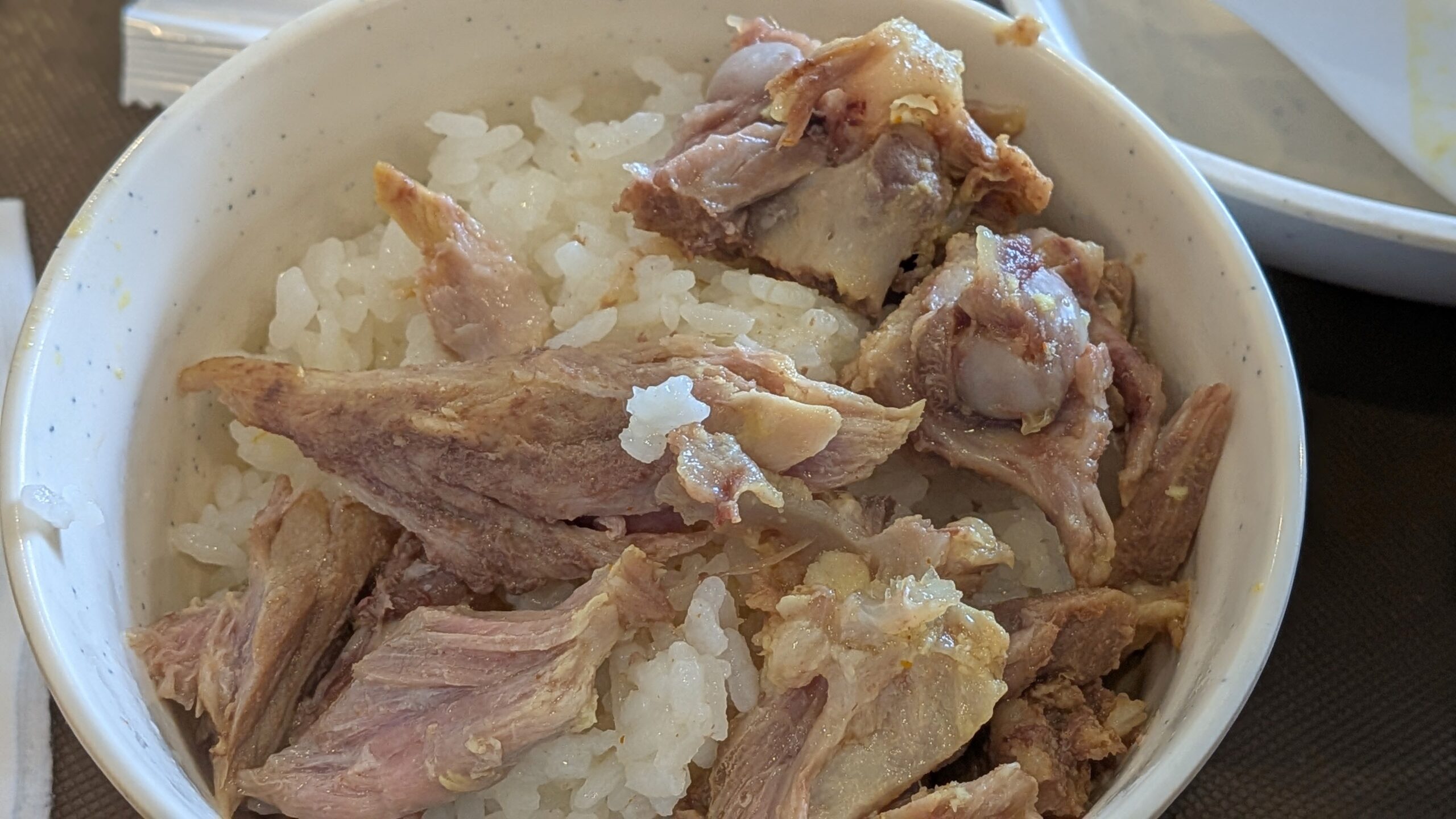 骨から外した肉をご飯にのせて